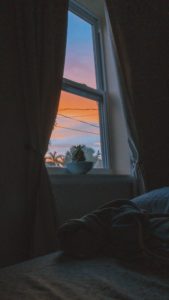 Photo of a sunset taken through a bedroom window.