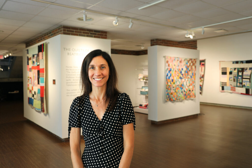 A woman stands in a museum gallery.