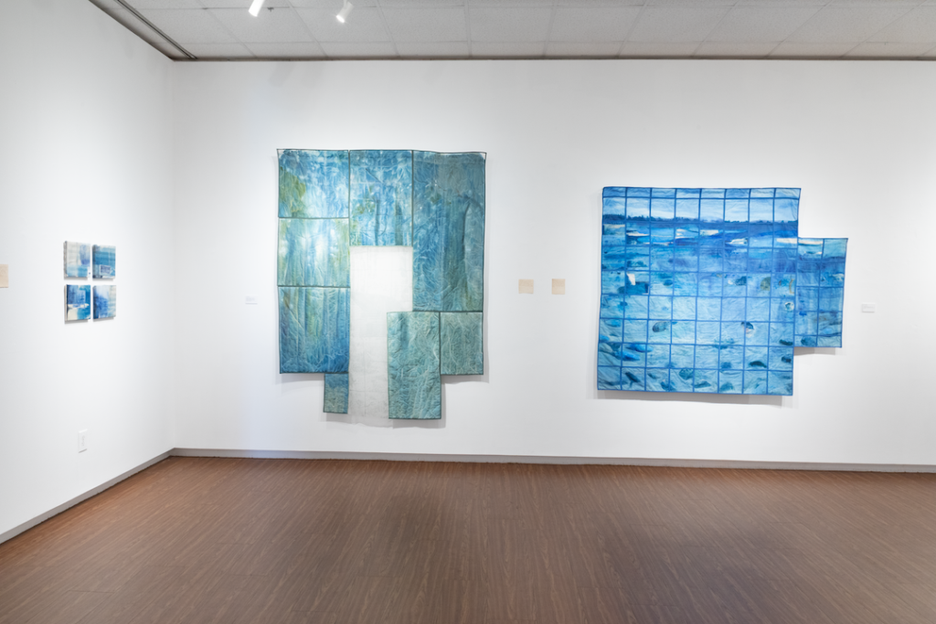 there are two paintings on the wall in a room with wood flooring