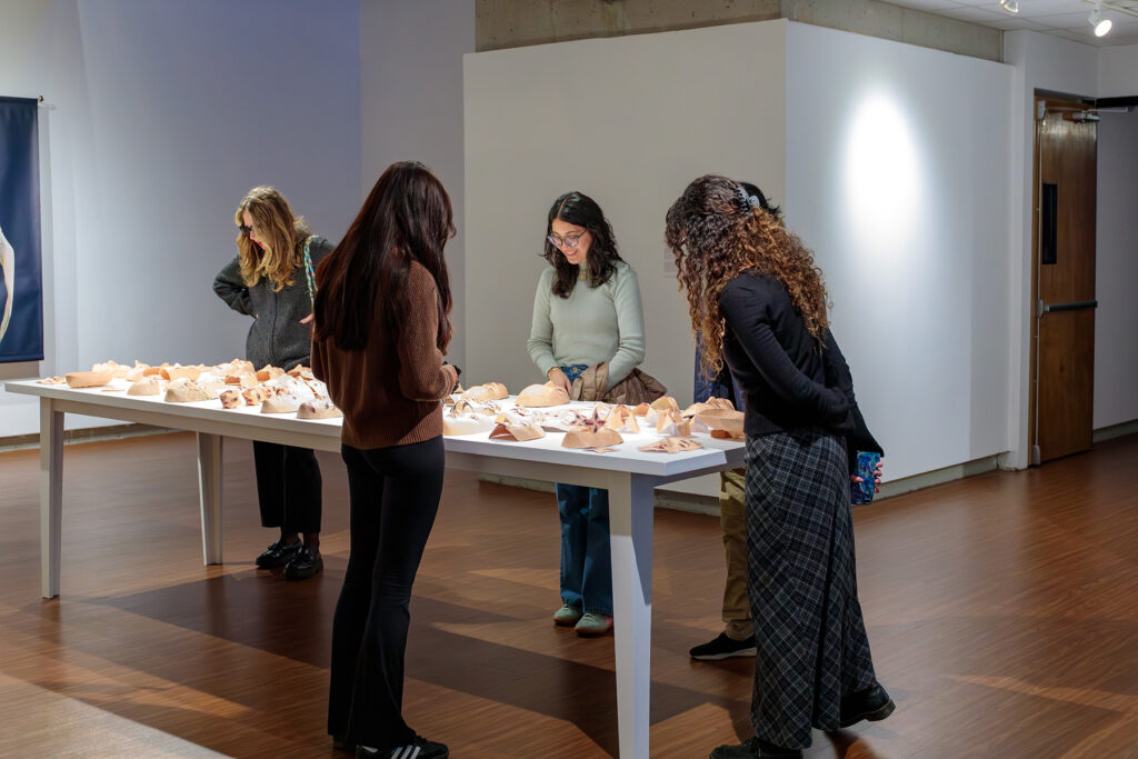 there are people standing around a table with food on it