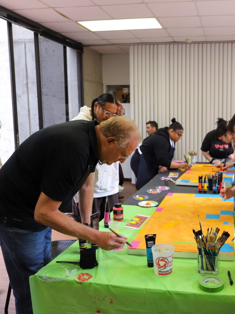 A man painting at a table. 
