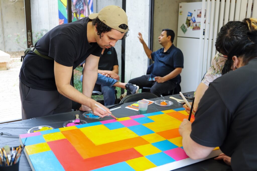 People painting a colorful canvas.